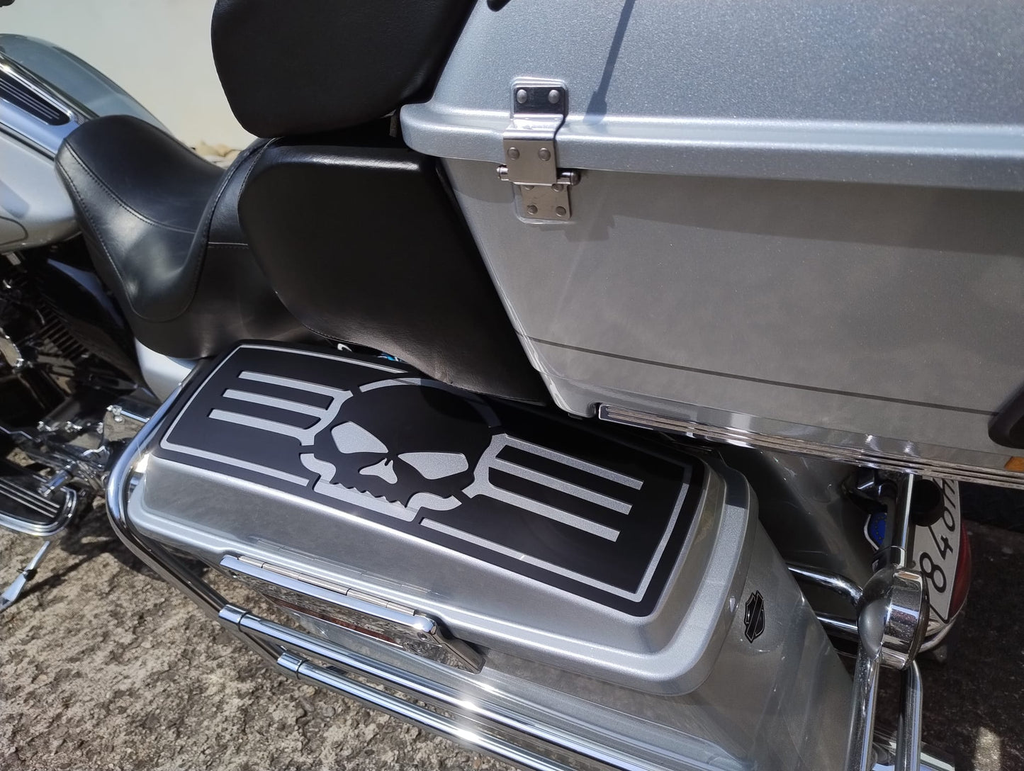 harley-davidson with a skull design on the step pad and a silver case.