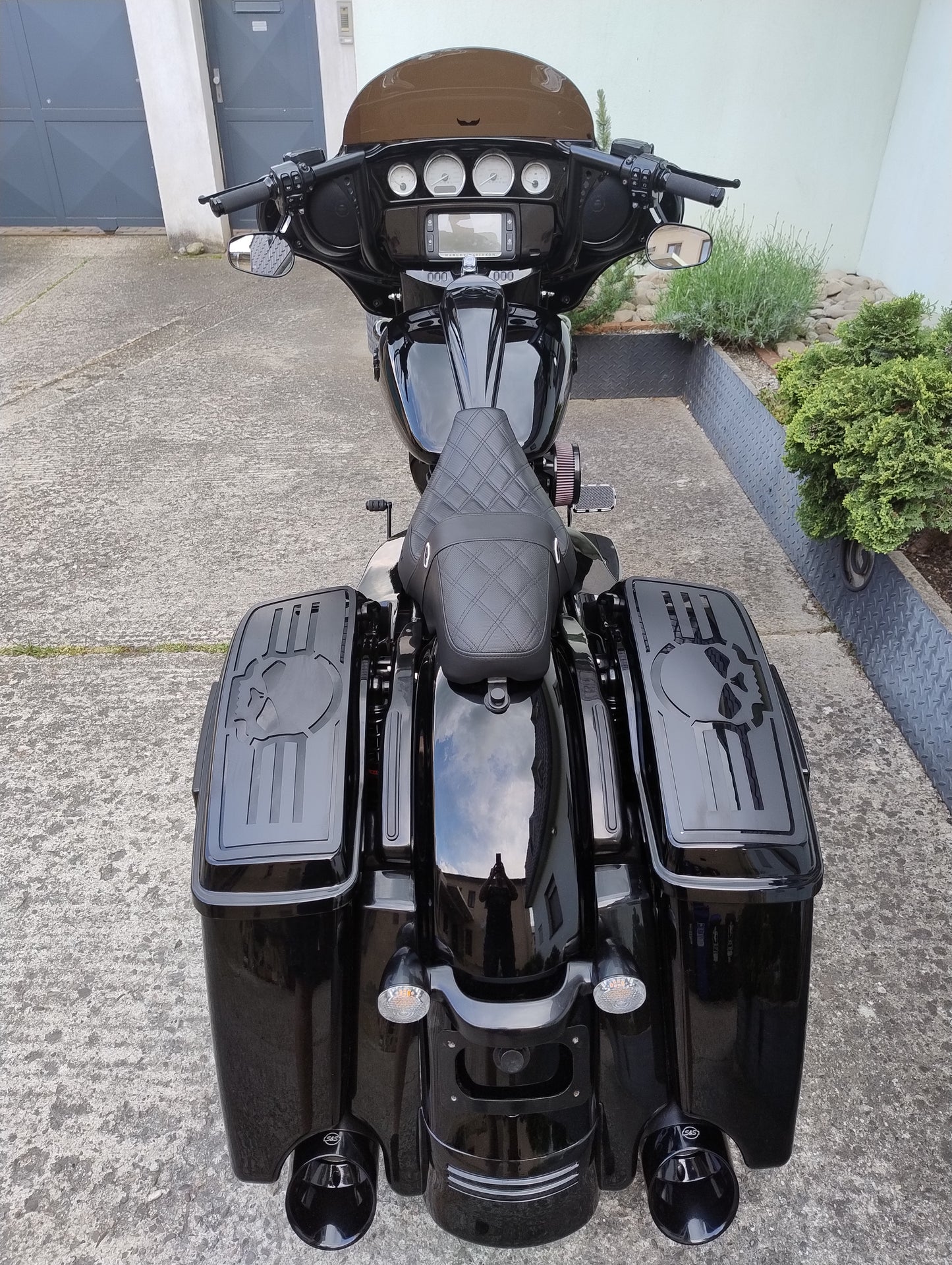 Black motorcycle with skull designs parked on a driveway.
