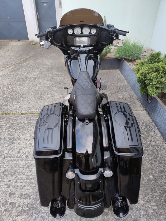 Black motorcycle with skull designs parked on a driveway.